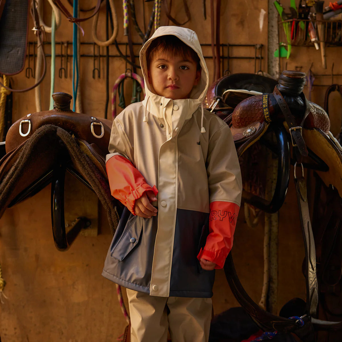 Child wearing Crywolf Ash Colourblock rain jacket outdoors