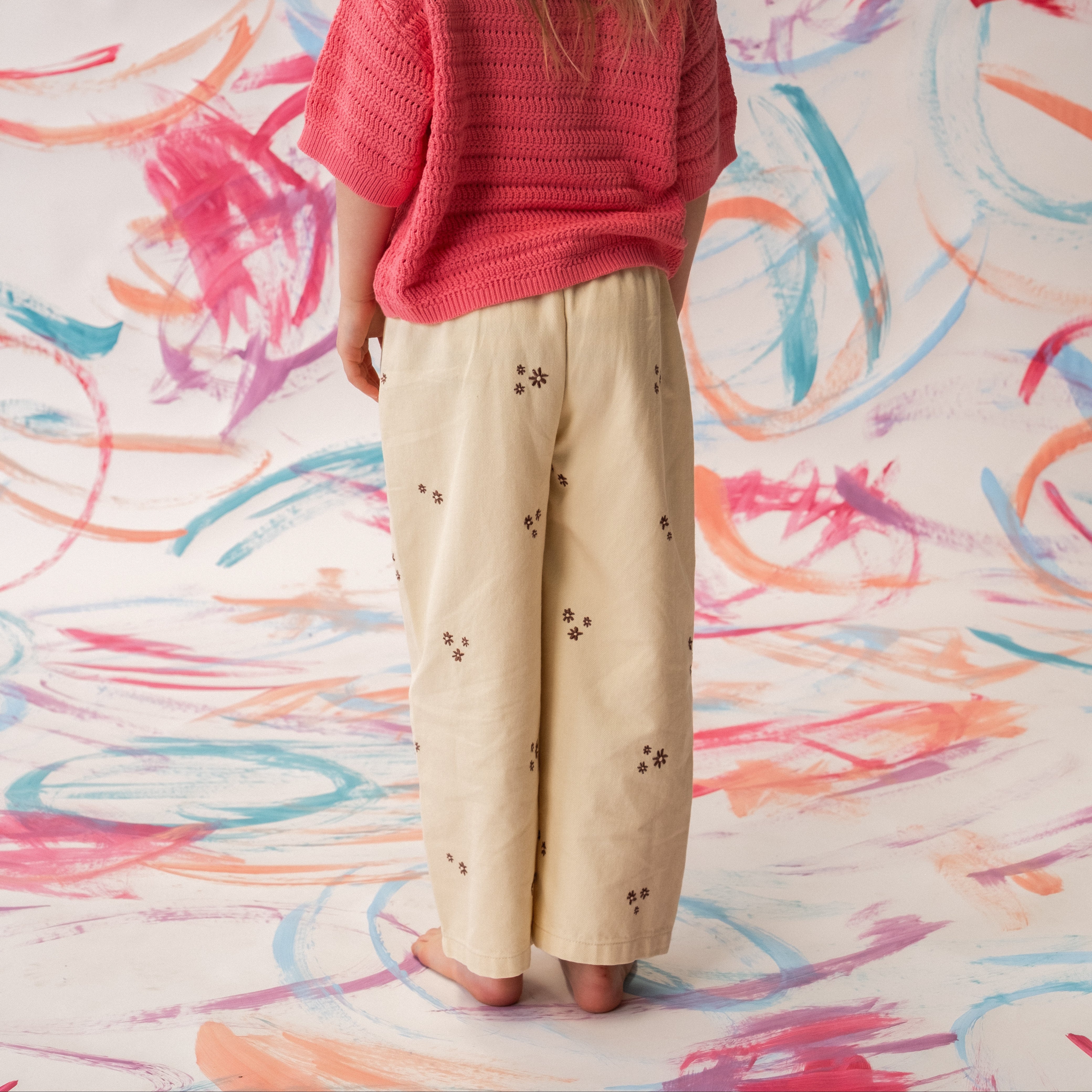 Organic denim pants in Milk with wild flower embroidery, front view