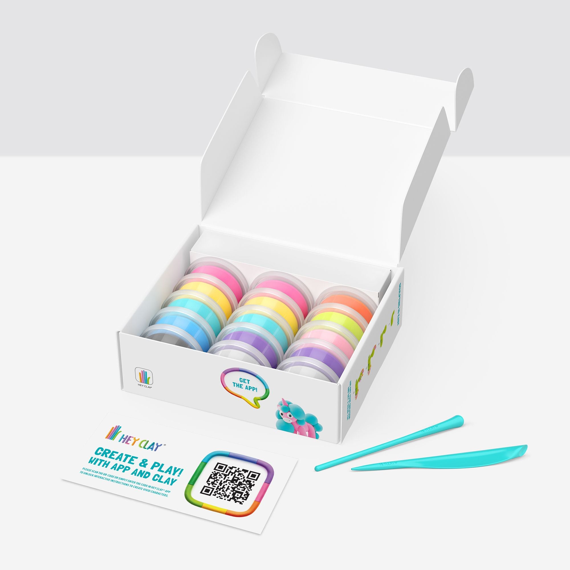 Box of colorful hey clay with a tool on a white background