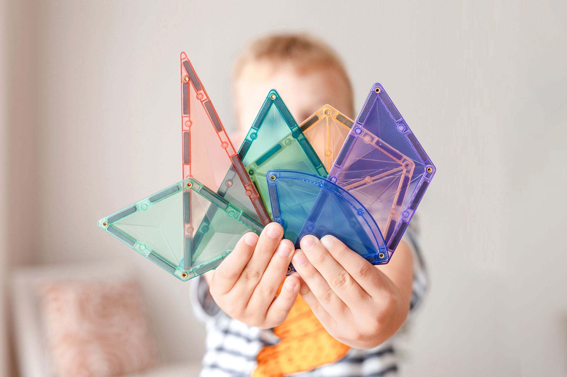 Assorted Connetix pastel magnetic tile shapes including pentagons, triangles, and trapezoids