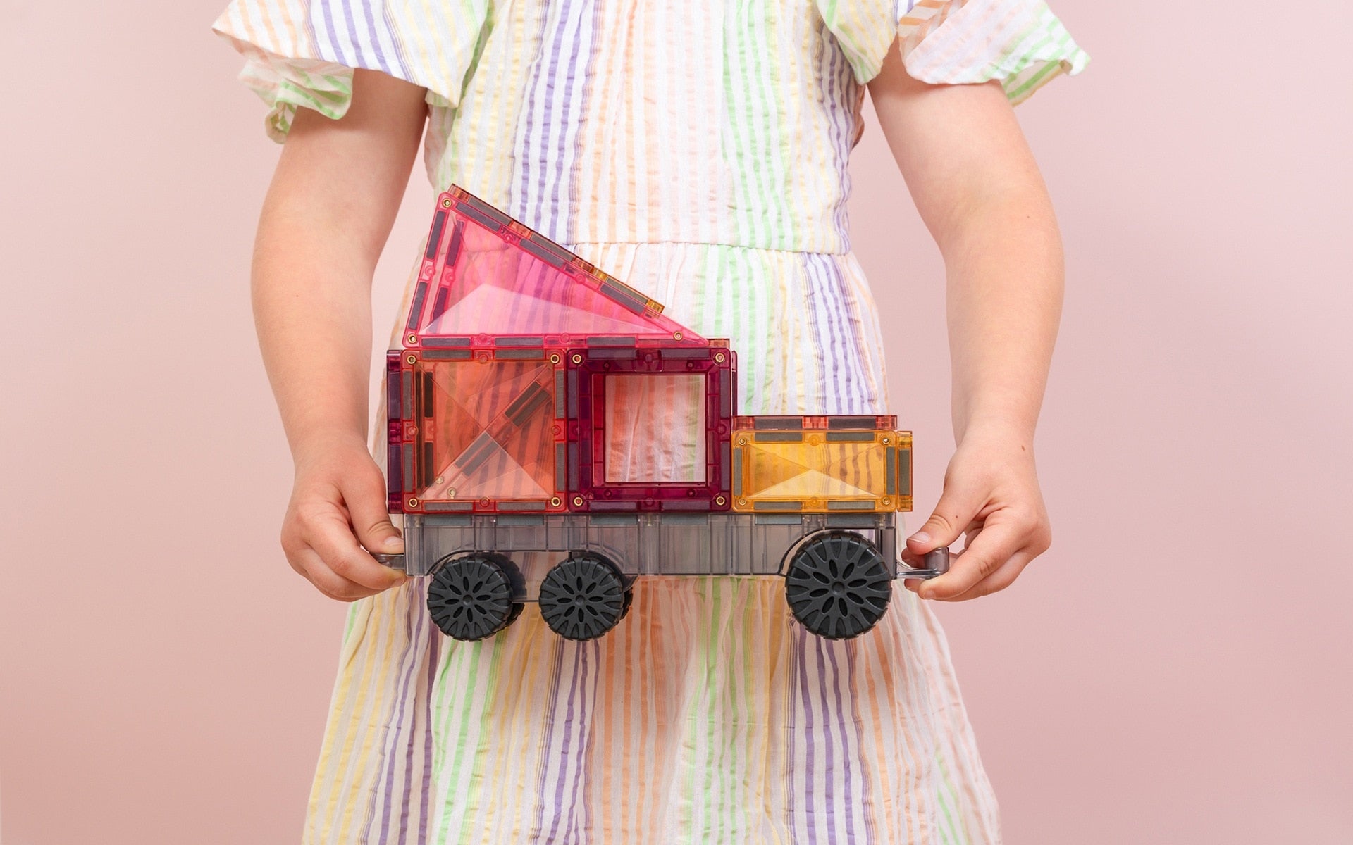 Children playing with Connetix Pastel Transport Pack – magnetic car and train pieces in action