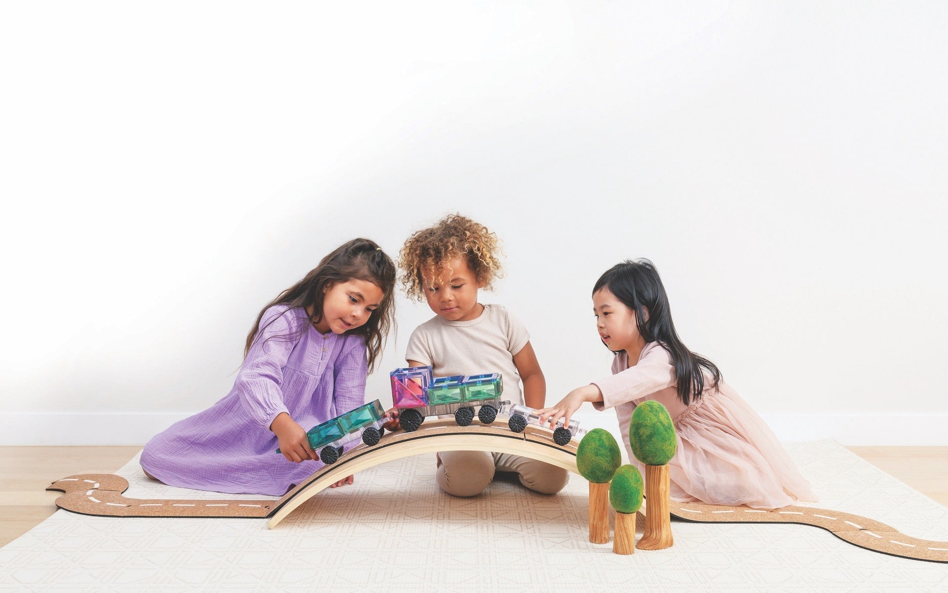 Children playing with Connetix Pastel Transport Pack – magnetic car and train pieces in action