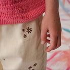 Close-up of wild flower embroidery detail on organic denim