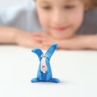 hey clay animal mega Blue clay sculpture of a creature with a child in the background