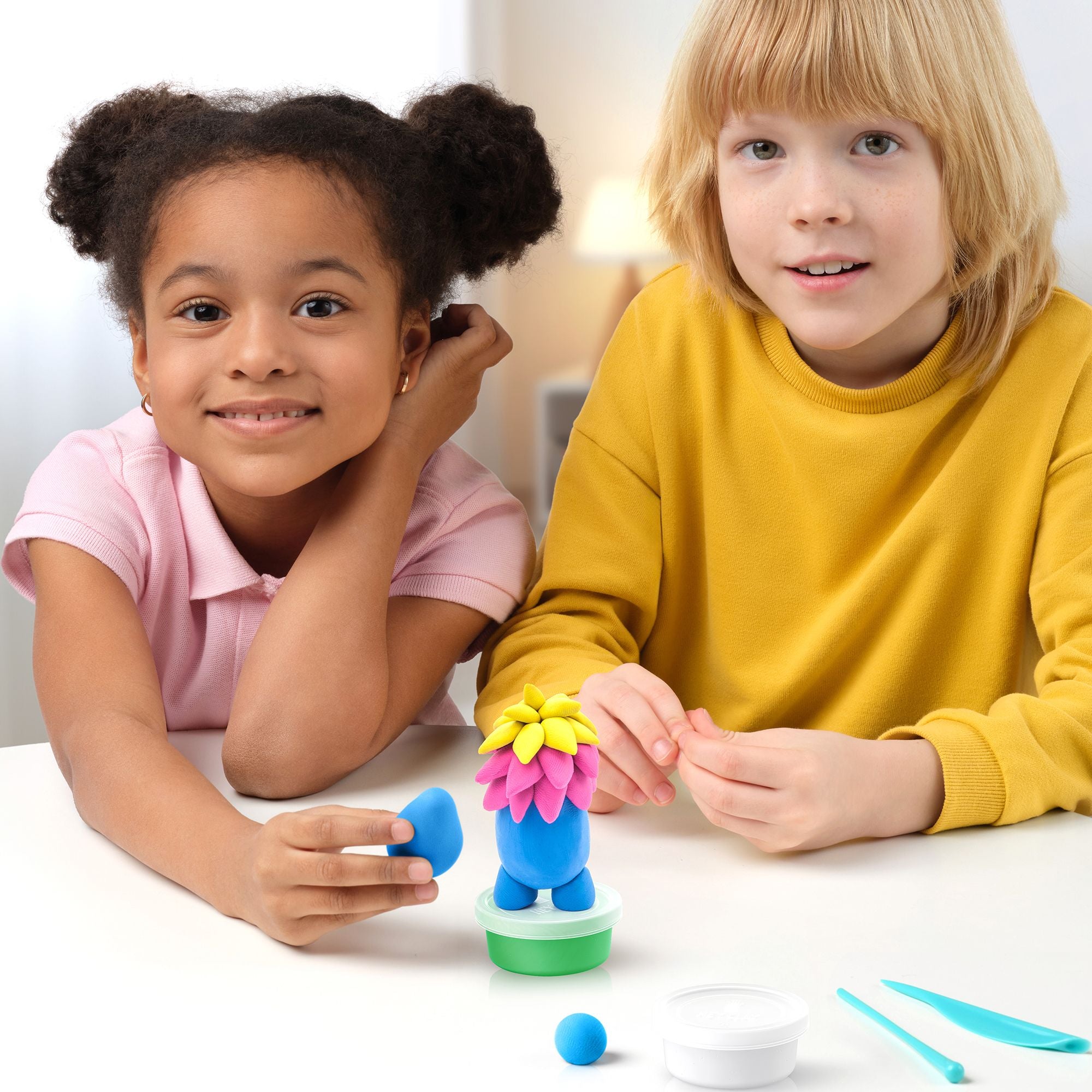 Two children playing with a colorful hey clay monsters set on a table.