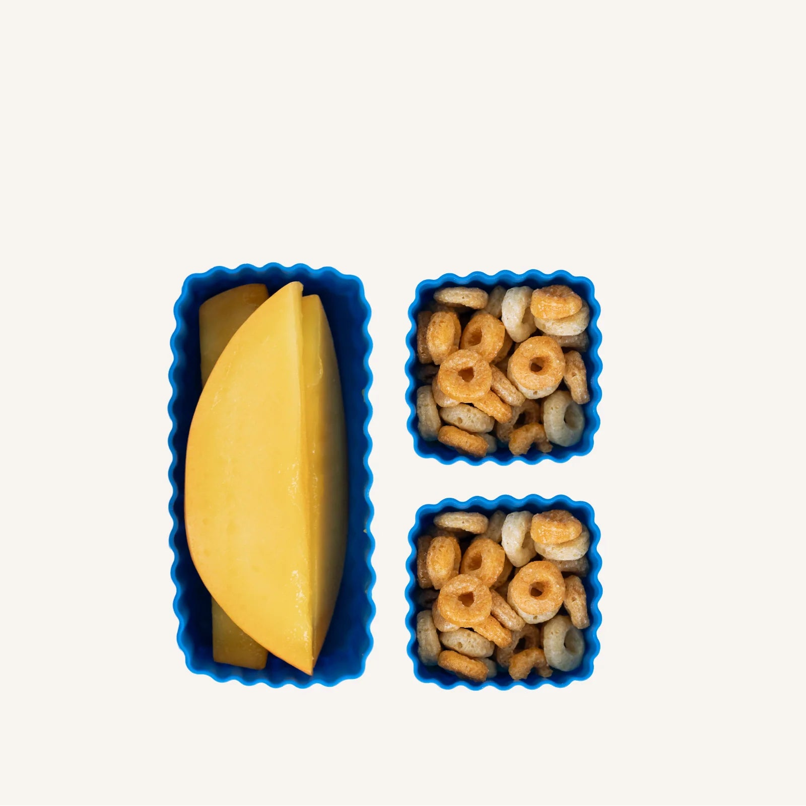 Three blue montiico bento mixed pack containers with food items on a white background